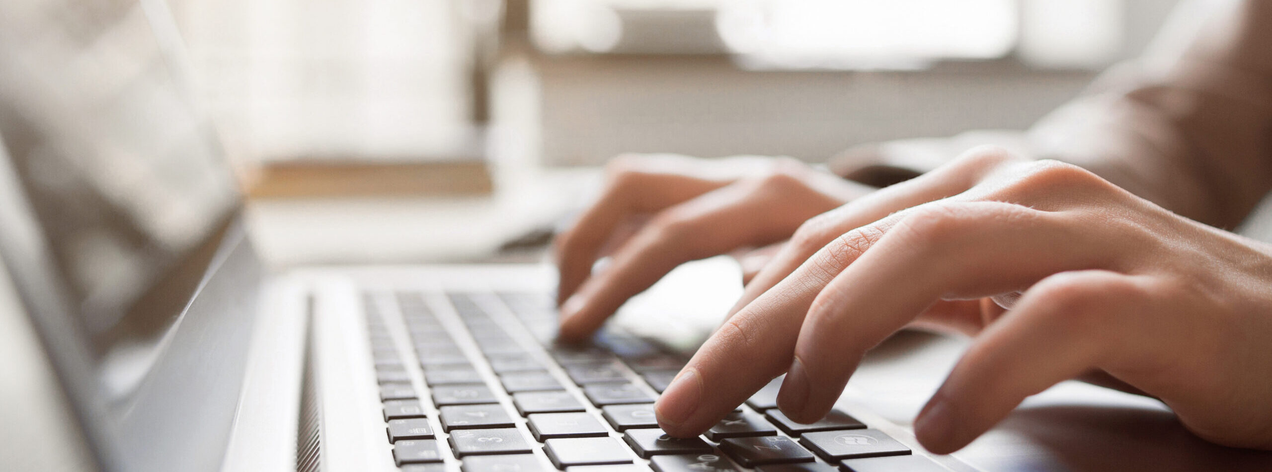 Typing on laptop closeup, chatting in Facebook